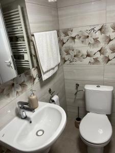 a bathroom with a white sink and a toilet at Вила Кичево in Varna City