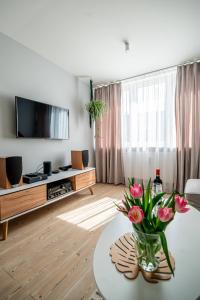 a living room with a vase of flowers on a table at Apartment by the Castle - top spot in Szczecin in Szczecin