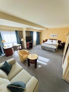 um quarto de hotel com uma cama e uma sala de estar em Hotel Le Châtelain em Bruxelas