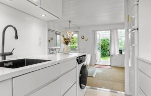 a white kitchen with a sink and a dishwasher at Nice Home In Faxe Ladeplads With Wifi in Fakse Ladeplads