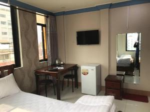 a hotel room with a bed and a table and a desk at RS Galaxy HOTEL in Phnom Penh
