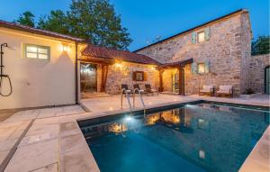 een zwembad voor een stenen huis bij Tonina in Pristeg