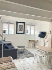 - un salon avec un canapé et une table dans l'établissement Lotentik residence, à La Rochelle