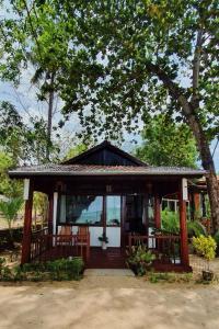 a small house with two chairs and a porch at Bamboo Cottages in Phu Quoc