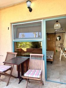 patio z 2 krzesłami, stołem i oknem w obiekcie H by Hambar w mieście Vama Veche