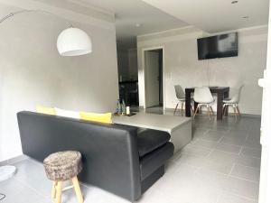 バート・ゾーデン・アム・タウヌスにあるCozy Apartment - Bad Soden - Free Parkingの黒いソファとテーブルのあるリビングルーム