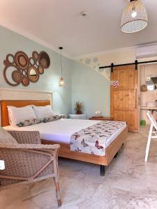 a bedroom with a large bed and a chair at H by Hambar in Vama Veche