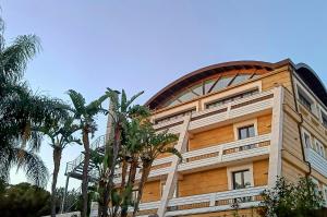 - un bâtiment avec une fenêtre ronde et des palmiers dans l'établissement UNICO Albatres Palace Salento by Life Resorts, à San Vito dei Normanni
