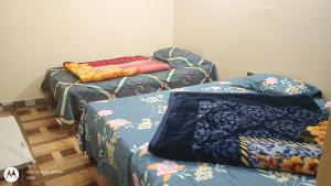 una camera con tre letti con coperte di Hotel vikash a Barkot