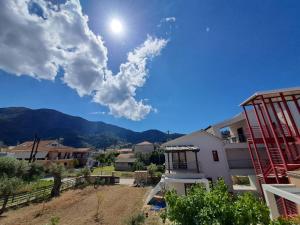 a blue sky with the sun and mountains in the background at Villa Don Kostangelo in Nikiana