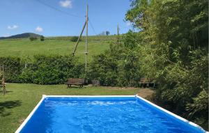 een blauw zwembad in een tuin met een bankje bij Amazing Apartment In Molino Del Piano With House A Panoramic View in Molino del Piano