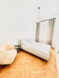 um quarto com uma cama, um sofá e uma cadeira em Квартири на вул Менцинського вул Куліша Форум em Lviv