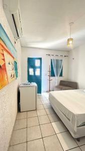 een slaapkamer met een bed en een blauwe deur bij Pousada Capitolio 01 - Canoa Quebrada - hospedagem in Canoa Quebrada