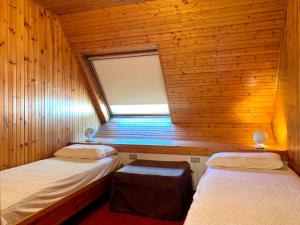 una camera con due letti in una cabina di legno di Trilocale Golf Club a Madonna di Campiglio