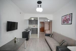 uma sala de estar com um sofá, uma mesa e uma cozinha em Orbi Residence Apartments em Batumi