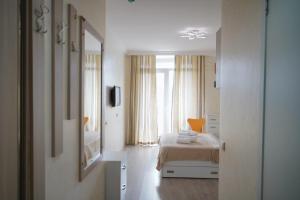 um quarto com uma cama e um espelho grande em Orbi Residence Apartments em Batumi