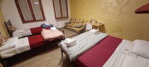 a room with two beds and a chair at Emmanueli65 fronte clinica per 4 matrimoniale e castello in Piacenza