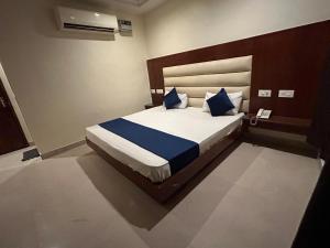 a bedroom with a large bed with blue pillows at Hotel Sapphire At New Delhi Railway Station in New Delhi