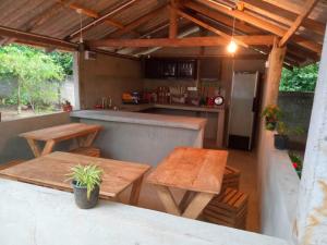 an outdoor kitchen with wooden tables and a counter at Saimon Villa in Mirissa