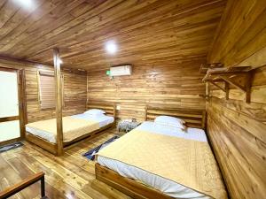 a bedroom with two beds in a wooden cabin at Cat Ba Love House in Cat Ba