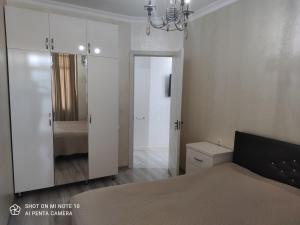 a bedroom with a bed and a large mirror at Апартамент семейный in Batumi