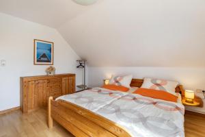 a bedroom with a large bed and a wooden dresser at Ferienwohnung Flensburg Mürwik in Flensburg