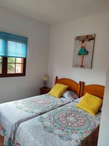two twin beds in a bedroom with a window at Casa Serena in Llanos de la Concepción