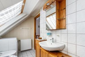 a bathroom with a sink and a toilet and a window at Ferienwohnung Flensburg Mürwik in Flensburg +11 photos