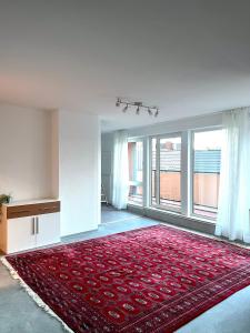 een woonkamer met een rood tapijt en een groot raam bij Penthouse Apartment Dortmund City in Dortmund