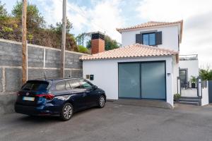 a blue car parked in front of a house at Melblue in Estreito da Calheta