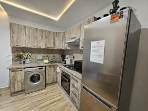 - un réfrigérateur en acier inoxydable dans une cuisine avec des placards en bois dans l'établissement MIA Appartement - résidence les champs du printemps, à Casablanca