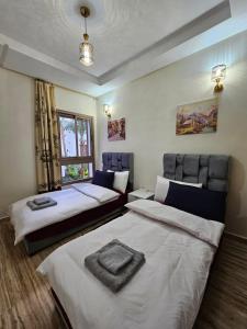 - une chambre avec 2 lits et une fenêtre dans l'établissement MIA Appartement - Élégance, Confort et Sérénité, à Casablanca