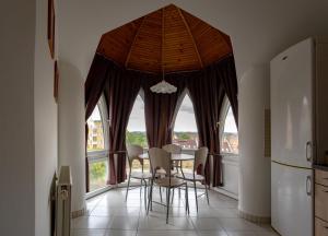 a dining room with a table and chairs and a large window at Six Corners Bright Corner Comfortable City Apartment in Pécs
