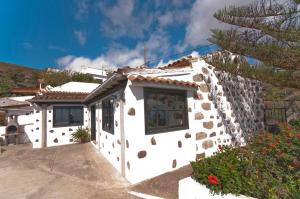 Casa blanca con pared de piedra en Cuevas Morenas, en Teror
