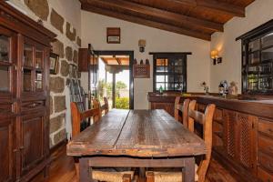 una sala da pranzo con tavolo e sedie in legno di Casa Rural Mi Perlita a Vega de San Mateo