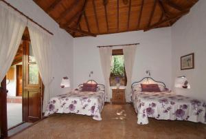 2 Betten in einem Zimmer mit weißen Wänden in der Unterkunft La Montaña in Santa Lucía