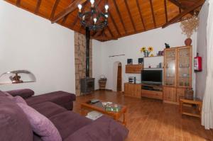 ein Wohnzimmer mit einem Sofa und einem TV in der Unterkunft La Montaña in Santa Lucía