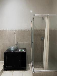 y baño con ducha y lavamanos. en Imogen Yogyakarta, en Yogyakarta