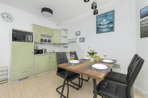 a kitchen and dining room with a table and chairs at Apartamenty Morskie Oko SeaView by Rent like home in Międzyzdroje