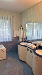 La salle de bains est pourvue de 2 lavabos et d'un grand miroir. dans l'établissement Crama Haiducilor, à Cluj-Napoca