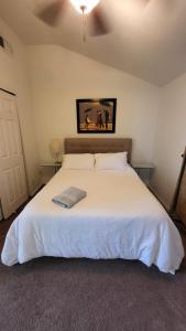 Un dormitorio con una cama blanca con una foto en la pared en U5 - Welcoming 2-Story 2 BR & 2 BA in DT PHX with pkg en Phoenix