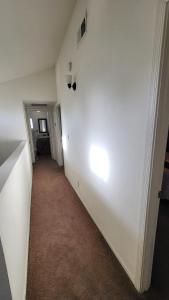 an empty hallway with a white wall and a light at U5 - Welcoming 2-Story 2 BR & 2 BA in DT PHX with pkg in Phoenix