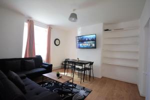 a living room with a couch and a table at Lovely 3 Bedroom Apartment in Standford Hill in London