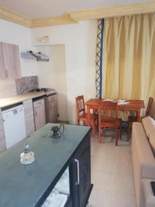 uma cozinha e uma sala de estar com uma mesa em Darna em El Haouaria