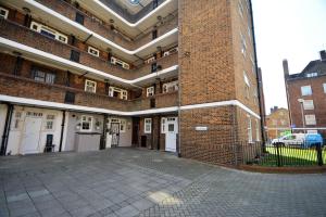 a large brick building with a large courtyard at Lovely 3 Bedroom Apartment in Standford Hill in London