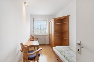a room with a desk and a bed and a table at Stadtappartement Sievers in Weil am Rhein