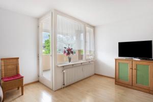 a living room with a window and a vase of flowers at Stadtappartement Sievers in Weil am Rhein