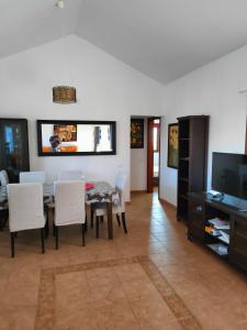 comedor con mesa, sillas y TV en Casa Serena, en Llanos de la Concepción