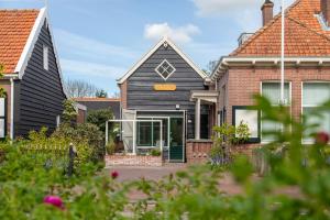 een huis met een zwart dak bij Vakantiehuis - Middelburgsestraat 61a - Koudekerke 'Villa Querina' in Koudekerke