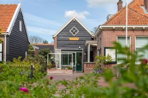 a house with a black roof at Welcome in - Vakantiehuis - Middelburgsestraat 61a - Koudekerke 'Villa Querina' in Koudekerke